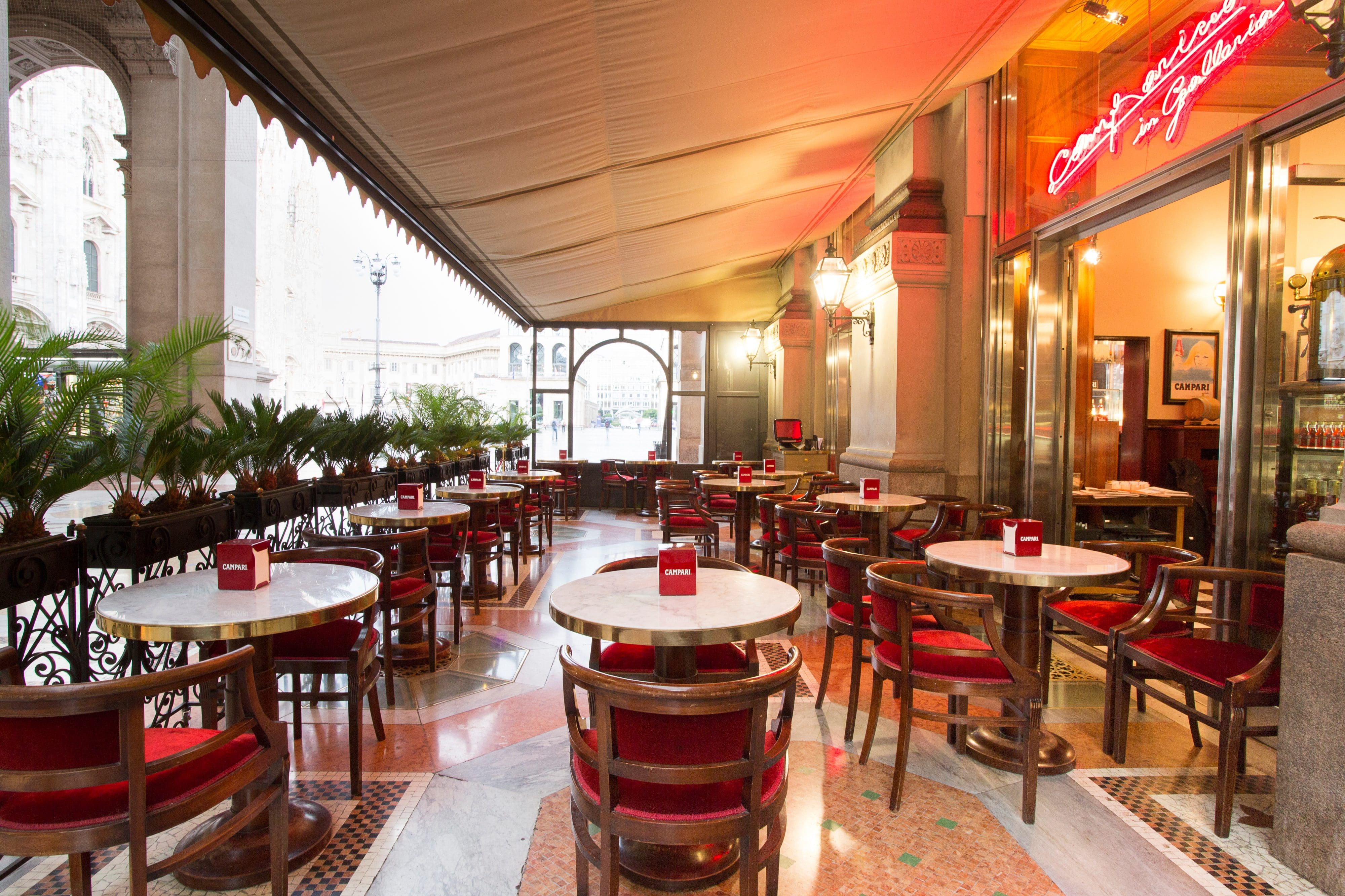 The outside terrace of Camparino in Galleria with its multi-coloured marble floor, vintage-style tables and chairs, and neon sign