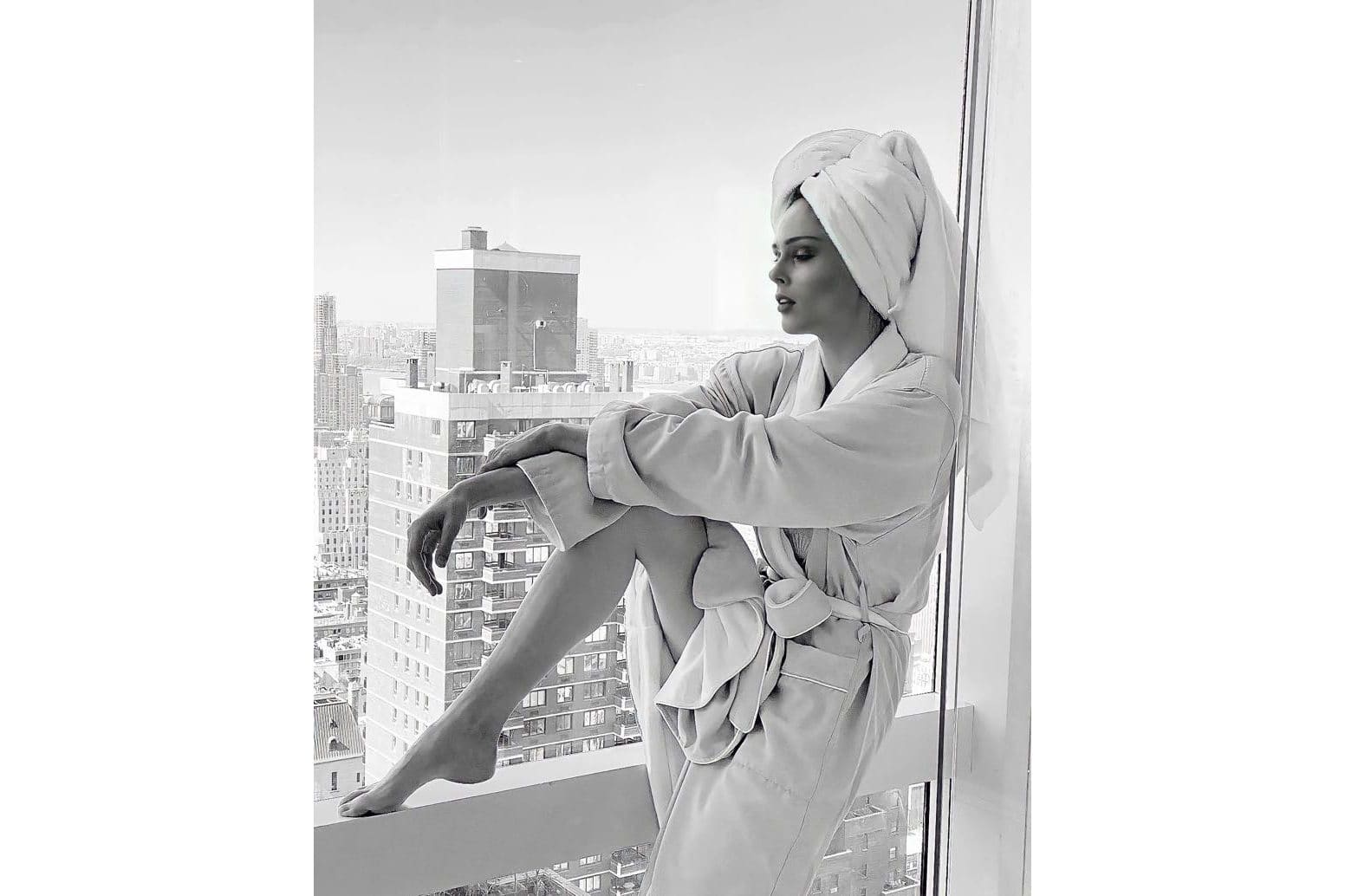 Coco Rocha poses in window wearing robe