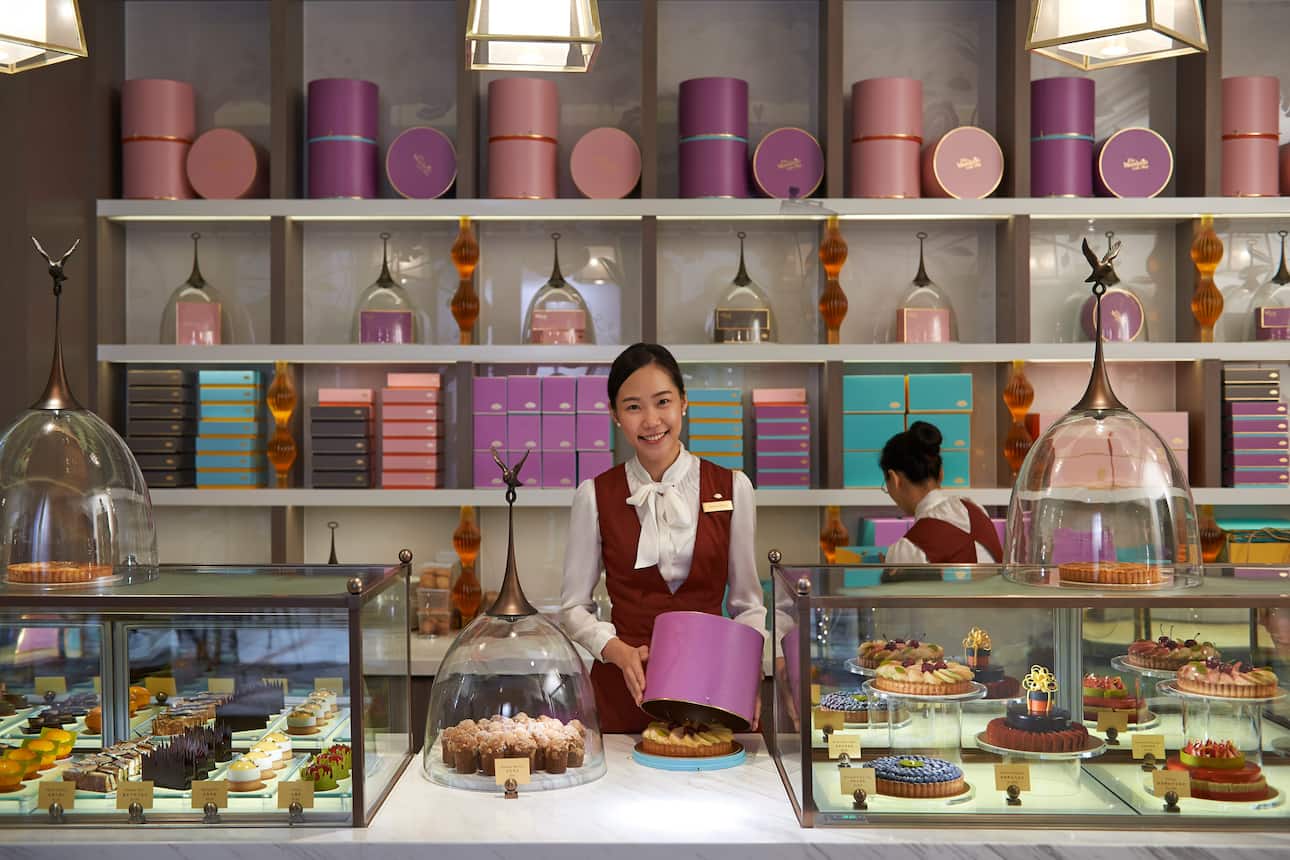 A woman surrounded by sweet treats at The Mandarin Cake Shop, Taipei 