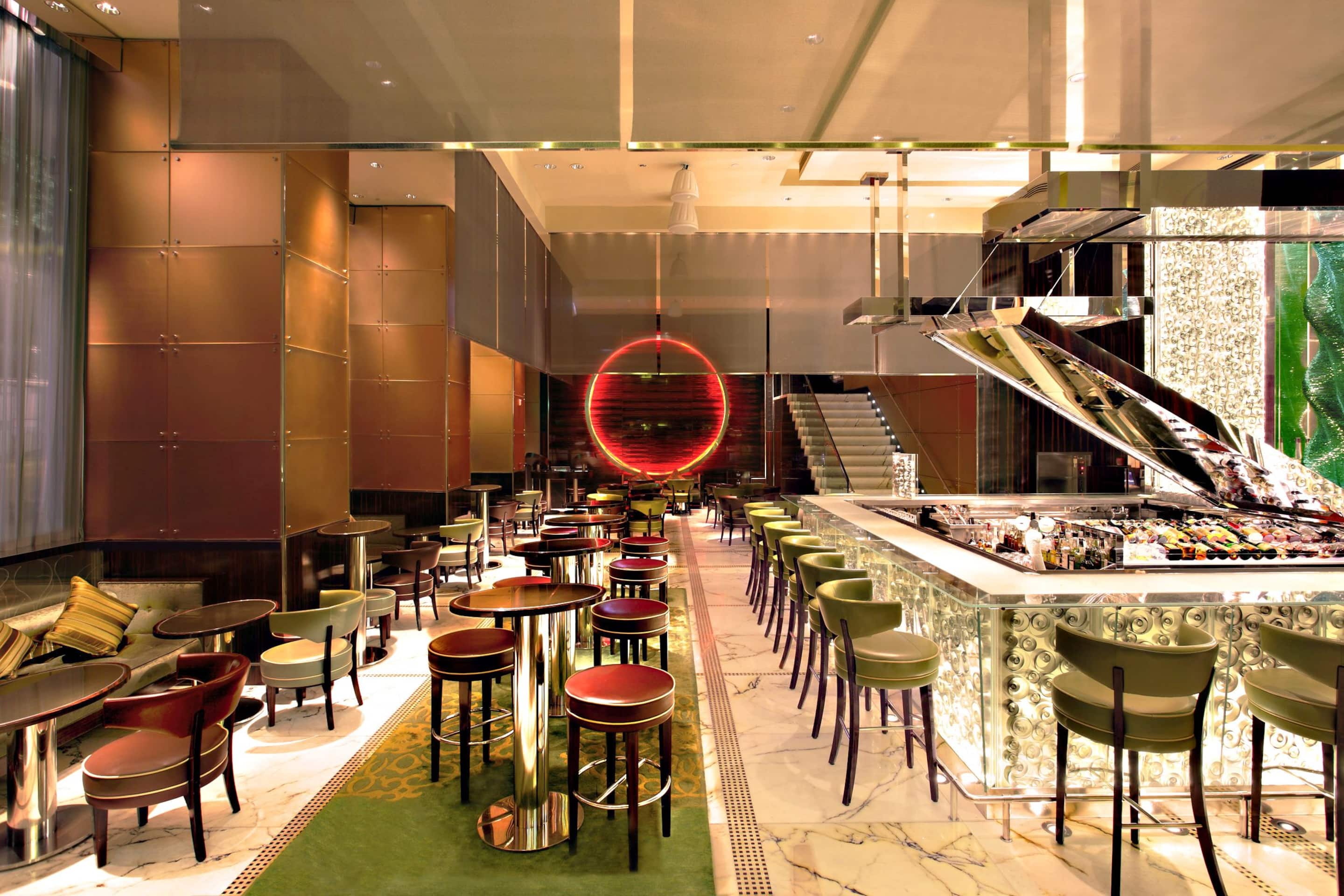 Plush furniture and the illuminated central bar inside MO Bar at The Landmark, Mandarin Oriental