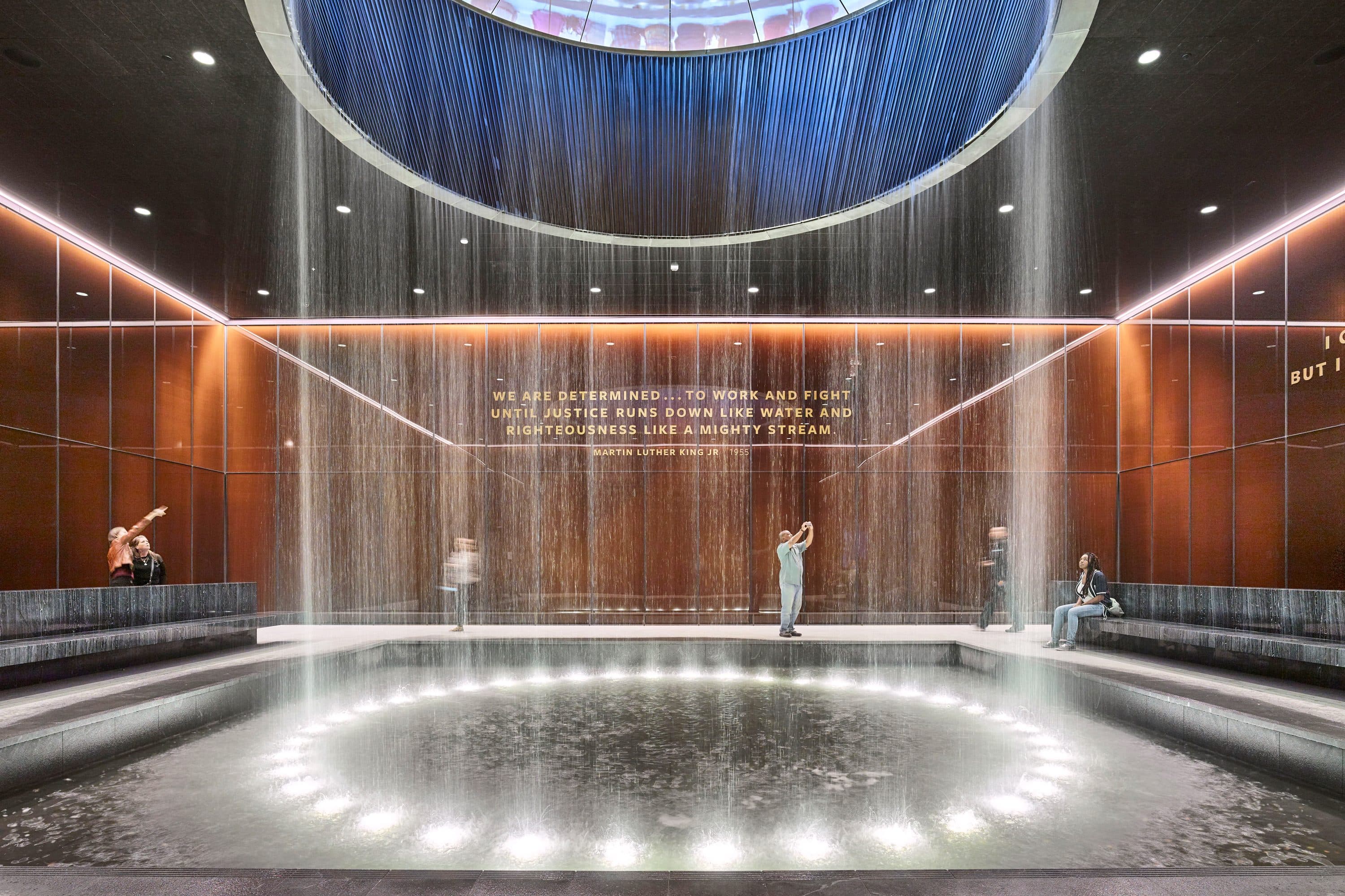 Visitors admire the metallic glass waterfall inside Contemplative Court 