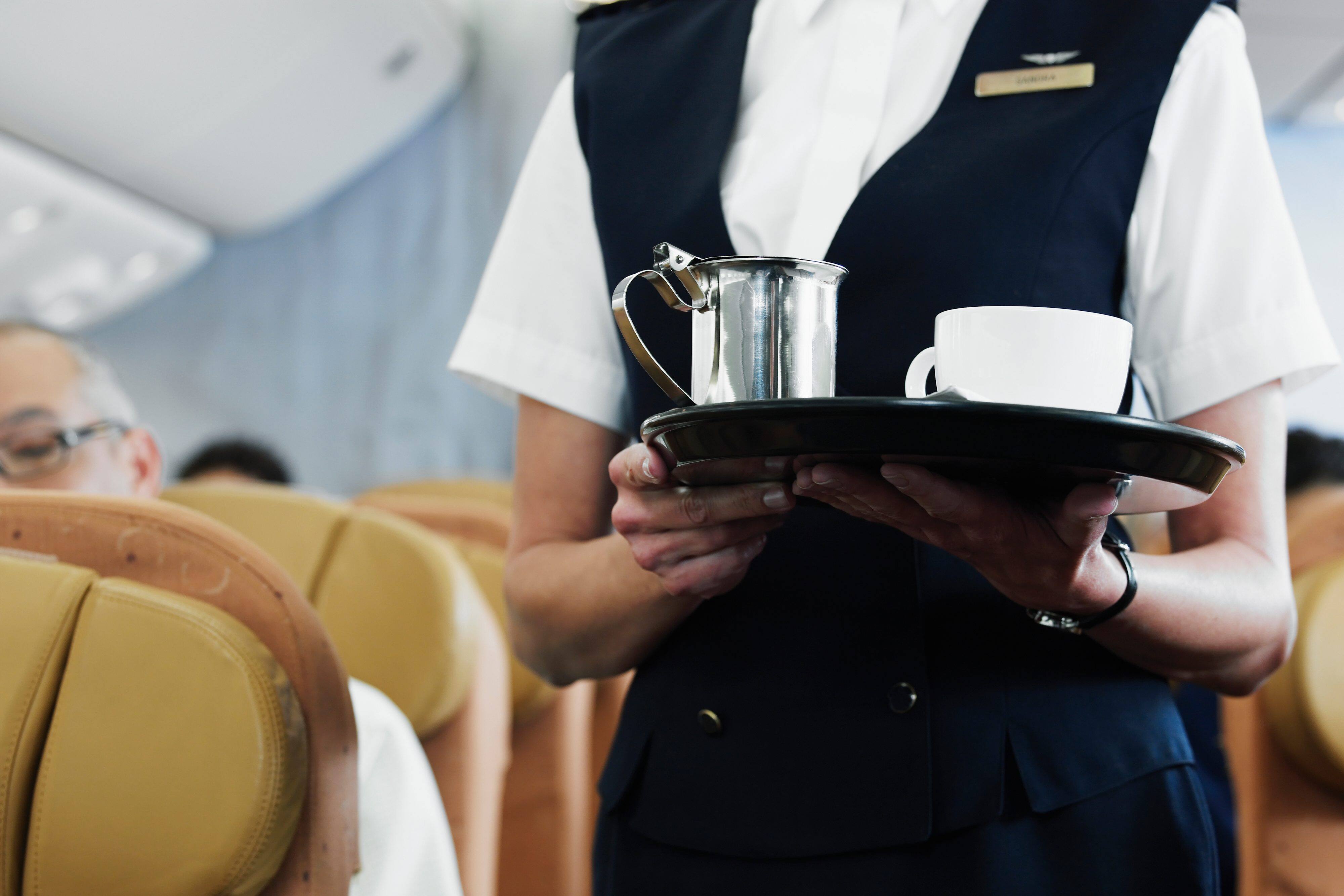 Flight attendant serving tea 
