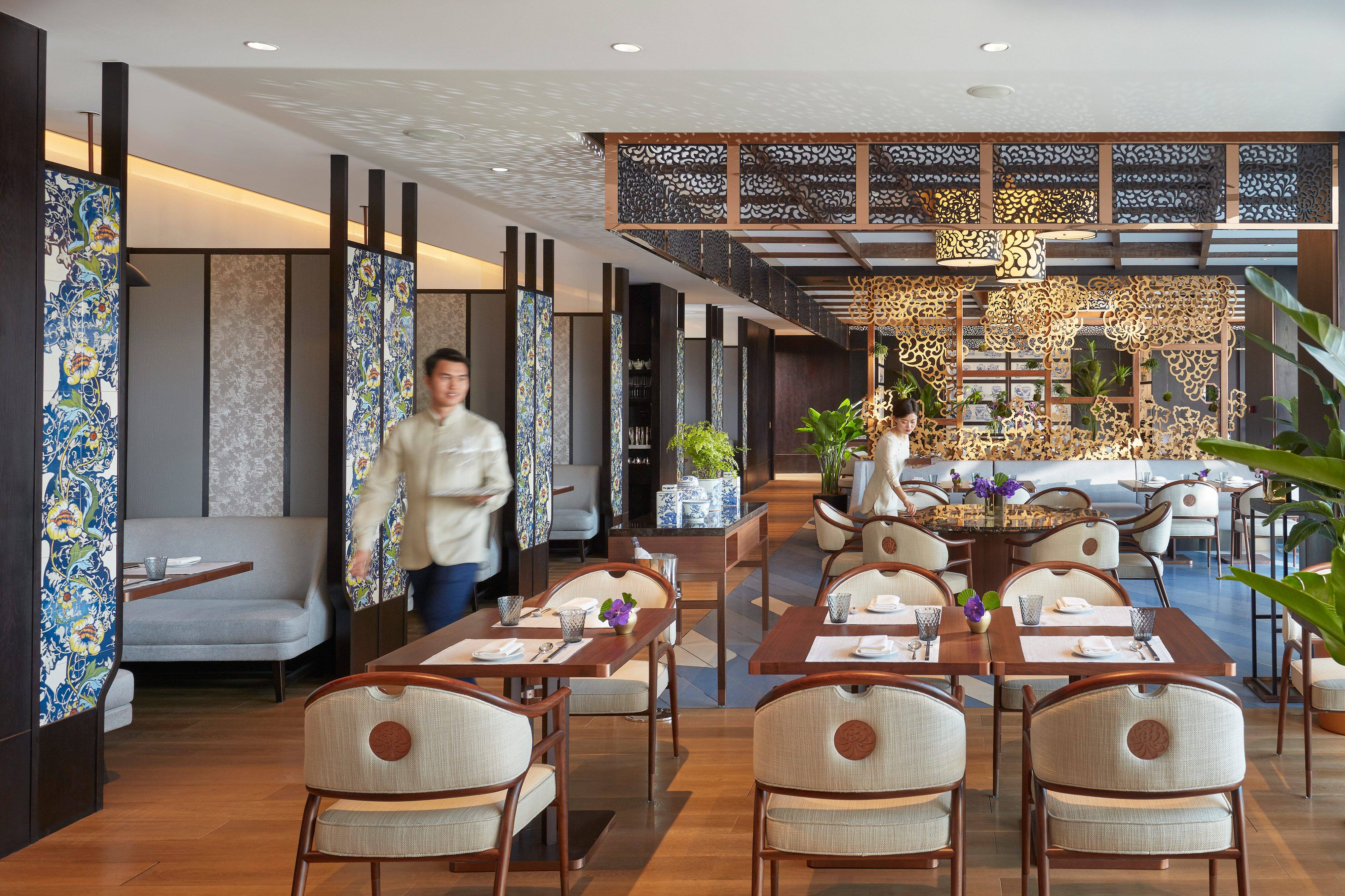 Waiters set tables inside Café Zi at Mandarin Oriental Wangfujing