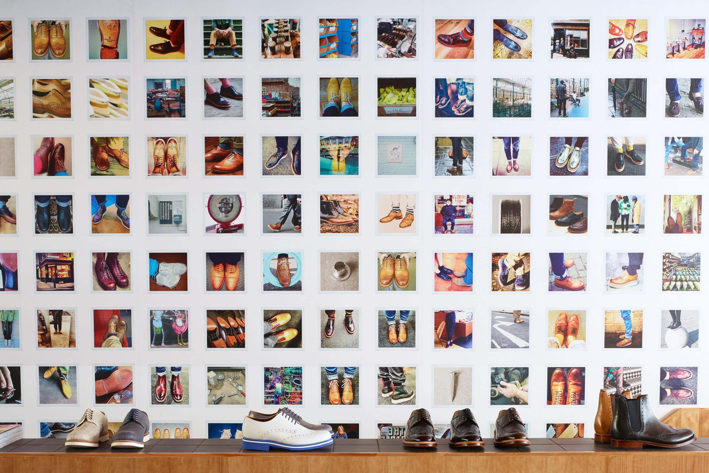 Mens shoes displayed in front of a colourful photography wall at Grenson shop, London
