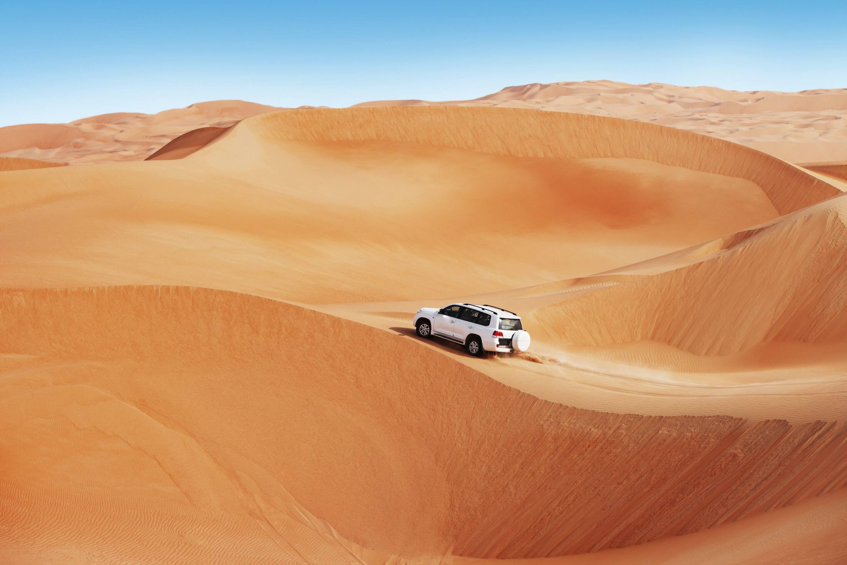 Dubai sand dune with car driving across
