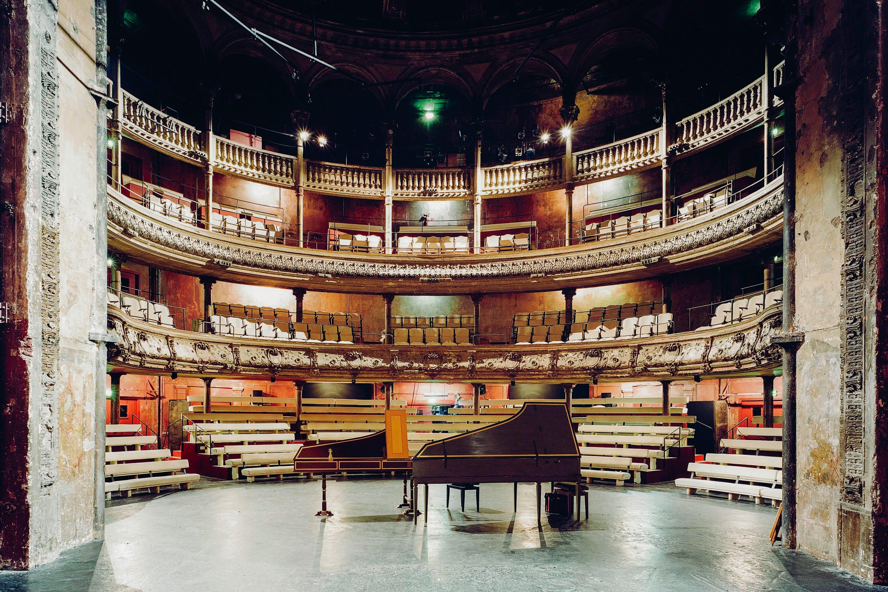 The empty auditorium of Bouffes du Nord as seen from the stage with two grand pianos in the foreground