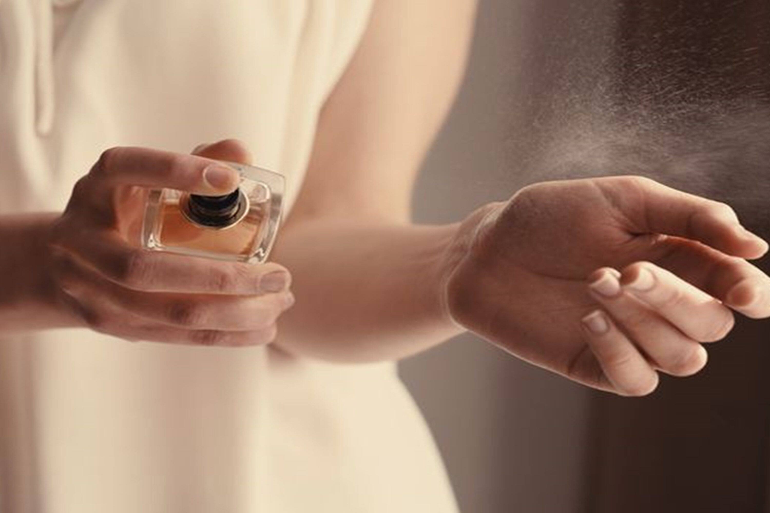Woman sprays fragrance onto her wrist
