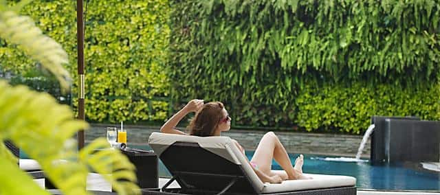 a woman relaxing on beach chair by the pool at mandarin oriental, jakarta
