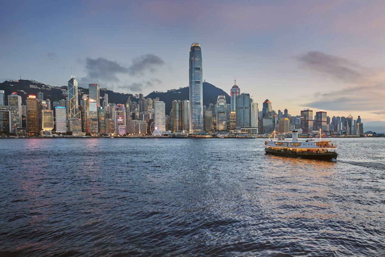 The Hong Kong Star Ferry crosses the harbour, backdropped by the city skyline 