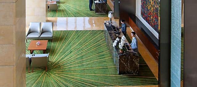 hotel lobby with green carpet and reception desk at mandarin oriental, macau