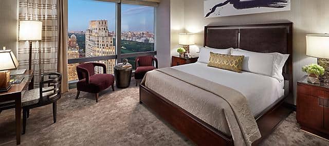 hotel room with ceiling to floor window and view of central park 