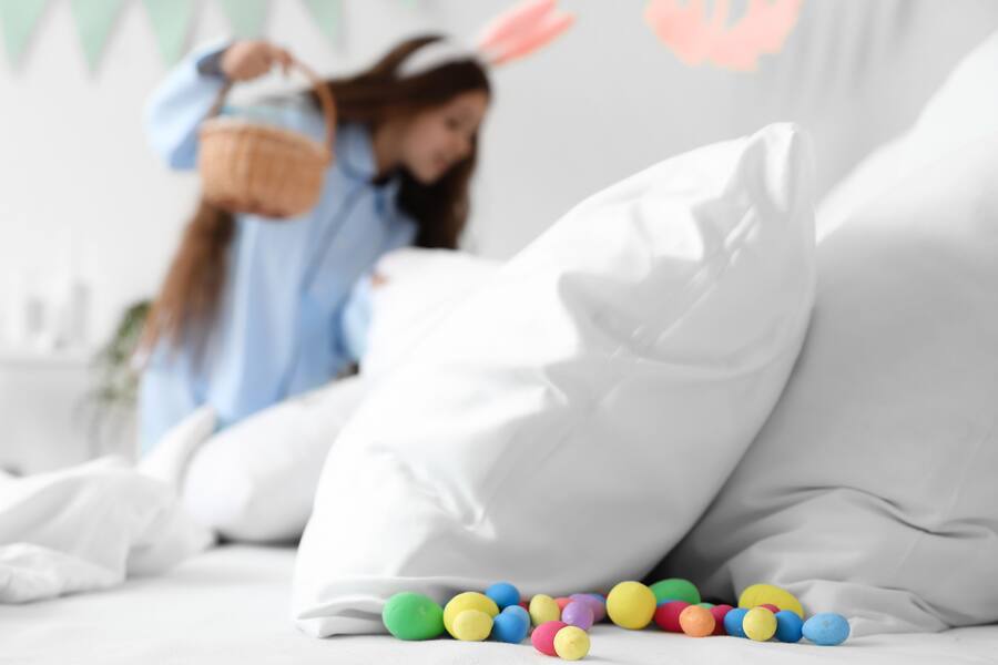young girl in bunny ears searches for easter eggs in a hotel bed from the Mandarin Oriental New York